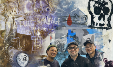 Artists standing in front of their artwork