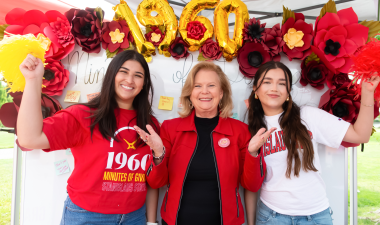 President Britt Rios-Ellis with students in front of the donor thank you board.
