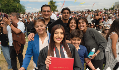 Graduating student poses with her family for a picture.