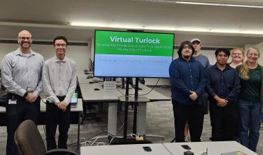Students and staff with city partners standing together in a computer lab