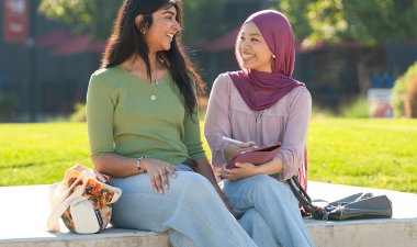 Two students sitting outdoors. 