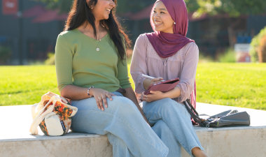 Two students sitting outdoors. 