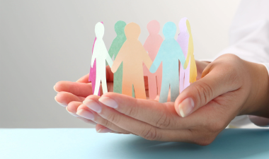 Hands holding paper people