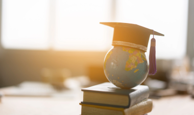 Graduation cap with globe and books