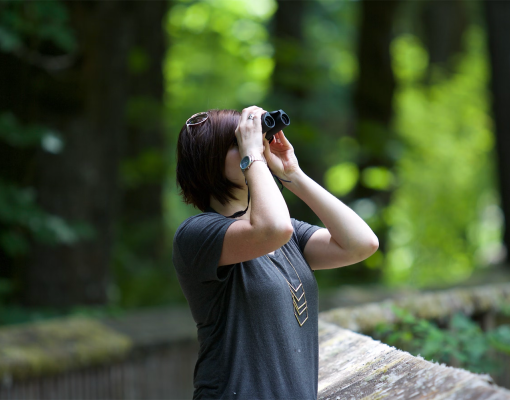 student looking through binoculars