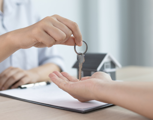 A person handing keys to another person