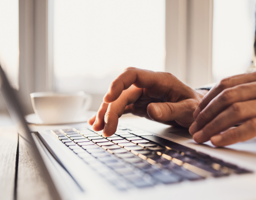 Hands typing on a computer