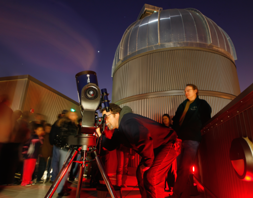 People on the Naraghi Hall rooftop, looking out of a telescope