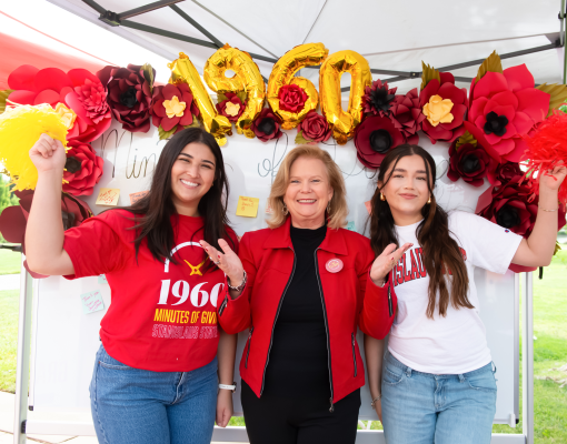 President Britt Rios-Ellis with students in front of the donor thank you board.
