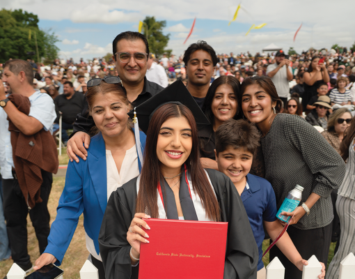 Graduating student poses with her family for a picture.