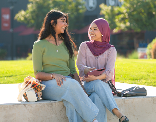 Two students sitting outdoors.