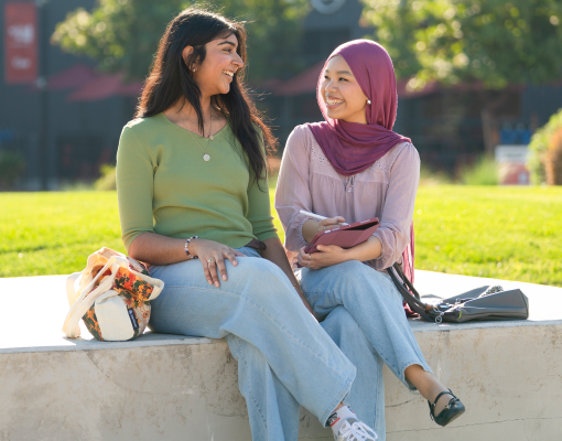 Two students sitting outdoors.