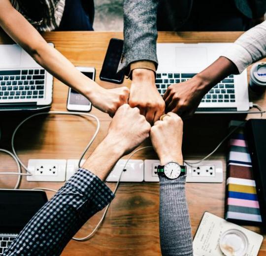 Team placing their hands together.