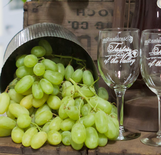 grapes next to empty wine glasses