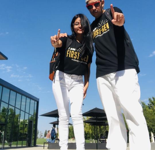 Two people standing next to each other in "First-Gen" shirts