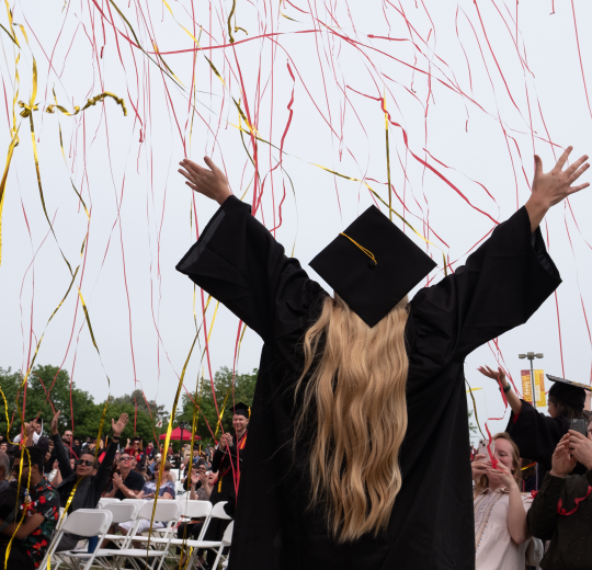 Graduate celebrating at commencement ceremony.