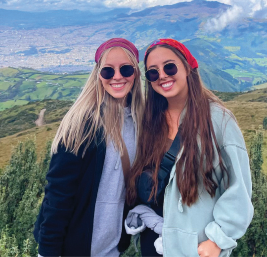 Two students take a photo together on a mountain in Equador.