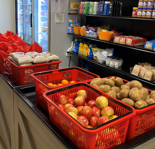 Photo of Inside of Turlock Food Pantry. Includes images of produce, shelving with food and toiletries, and fridge and freezer. 