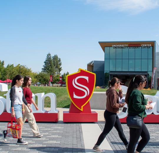 prospective students walking in front of Stan State sign