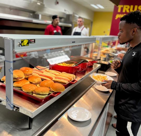 student standing by main dining counter