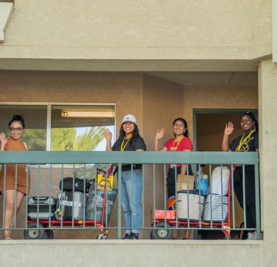 students waving at the camera on move in day