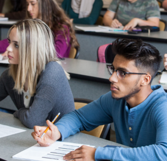 A group of students taking notes during a biology lecture.