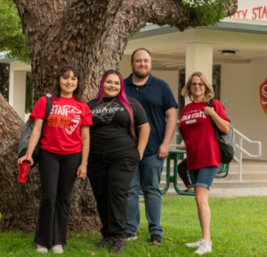 Four students stand at the front of the Stockton Campus