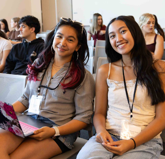 Two female first year students smiling for the camera at orientation