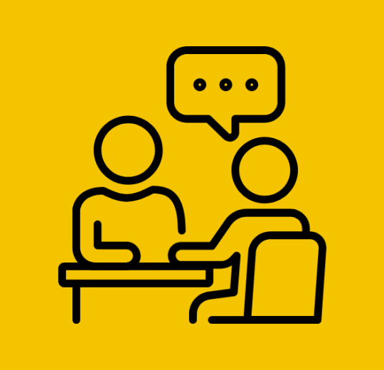 Icon of two people seated across from each other at a table, with a speech bubble above them indicating a conversation or advising session.