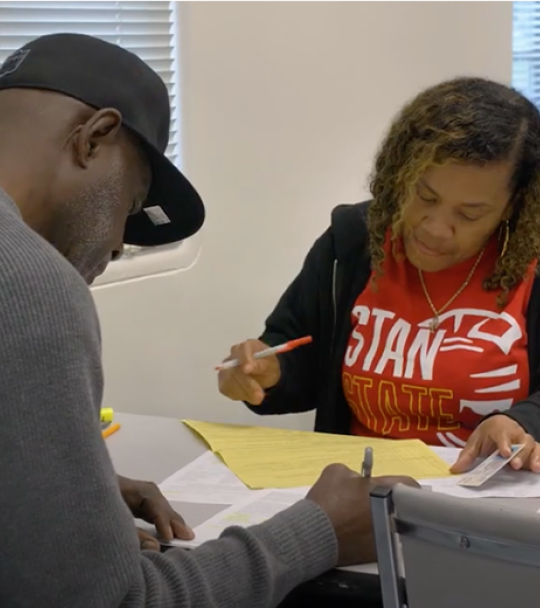 A Stan State student assists a community member with their income tax return.