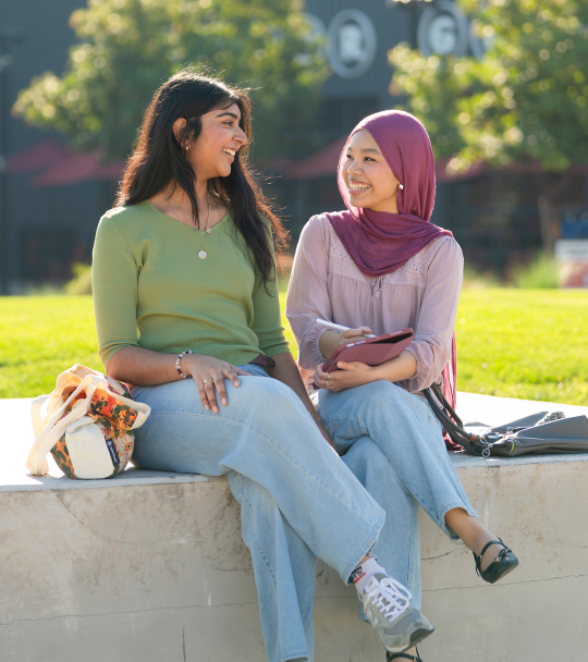 Two students sitting outdoors. 
