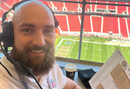 Steven Flowers holding up a statistics sheet in the press box of Levi's Stadium.