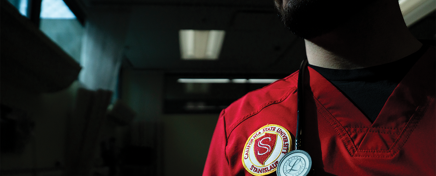 Nursing student detail of shield on scrub and stethoscope