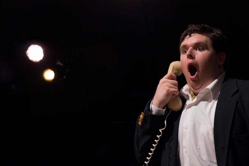 Actor holds phone with look of horror on his face