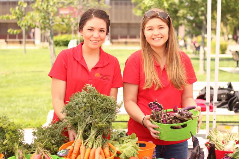 Students sell campus-grown vegetables at farmers market on Quad